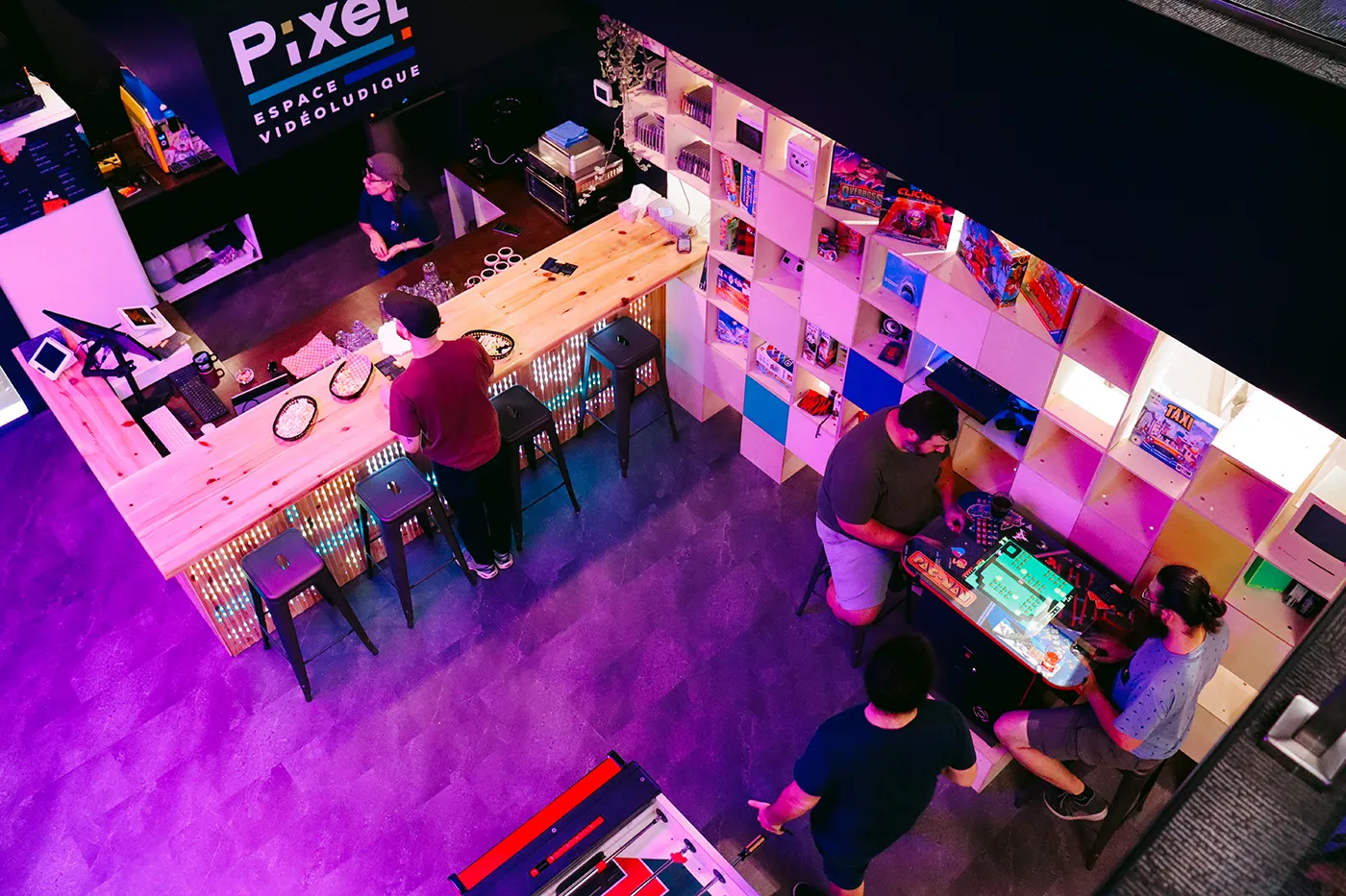Soirée entre collègues au comptoir et dans la salle de jeux du Pixel, vus d'en haut