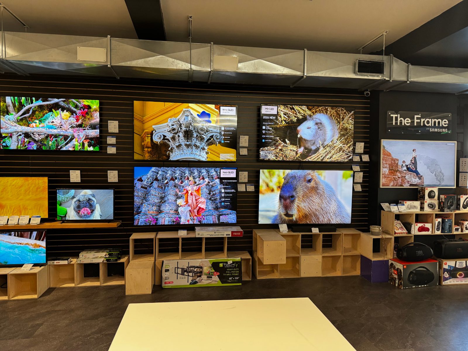 Le mur de téléviseurs Samsung et d'enceintes JBL, avec les étiquettes stereo+, au magasin Plan B